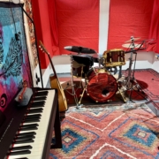 Music studio with a drum, a piano and a desk