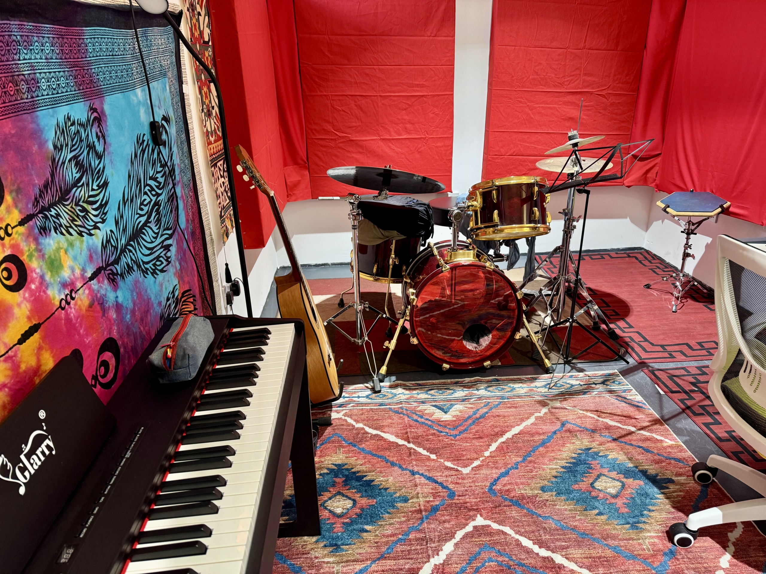 Music studio with a drum, a piano and a desk
