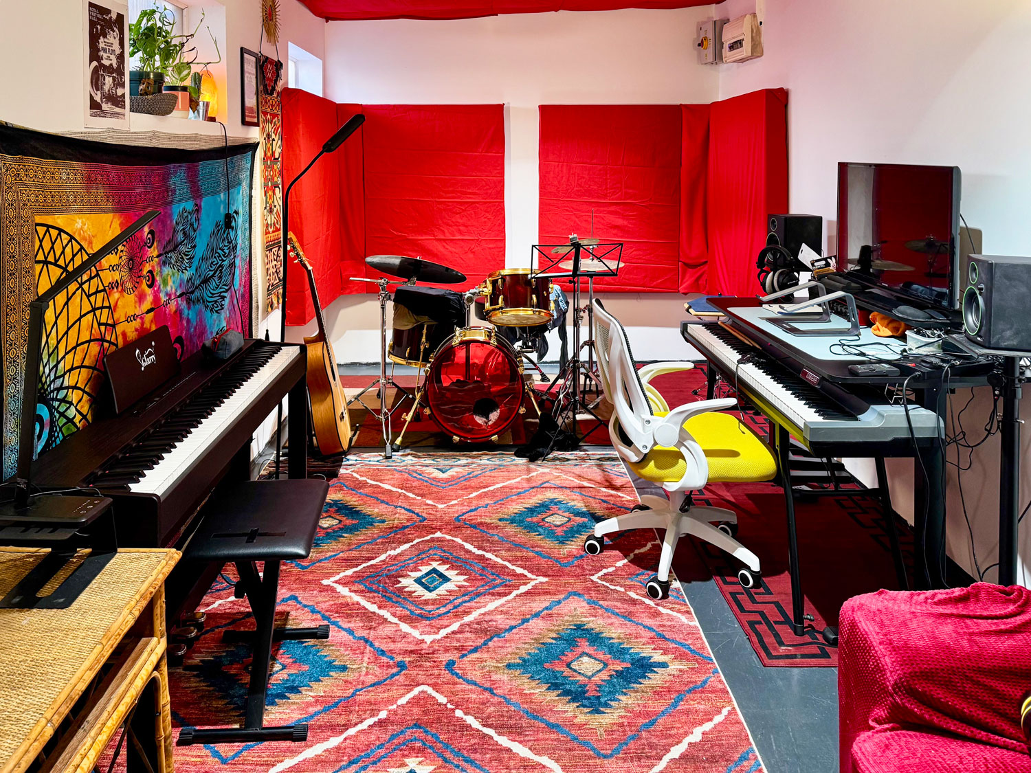 Music studio with a drum, a piano and a desk