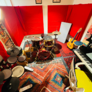 Music studio with a drum, a piano and a desk