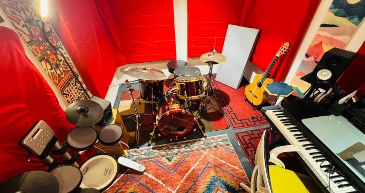 Music studio with a drum, a piano and a desk